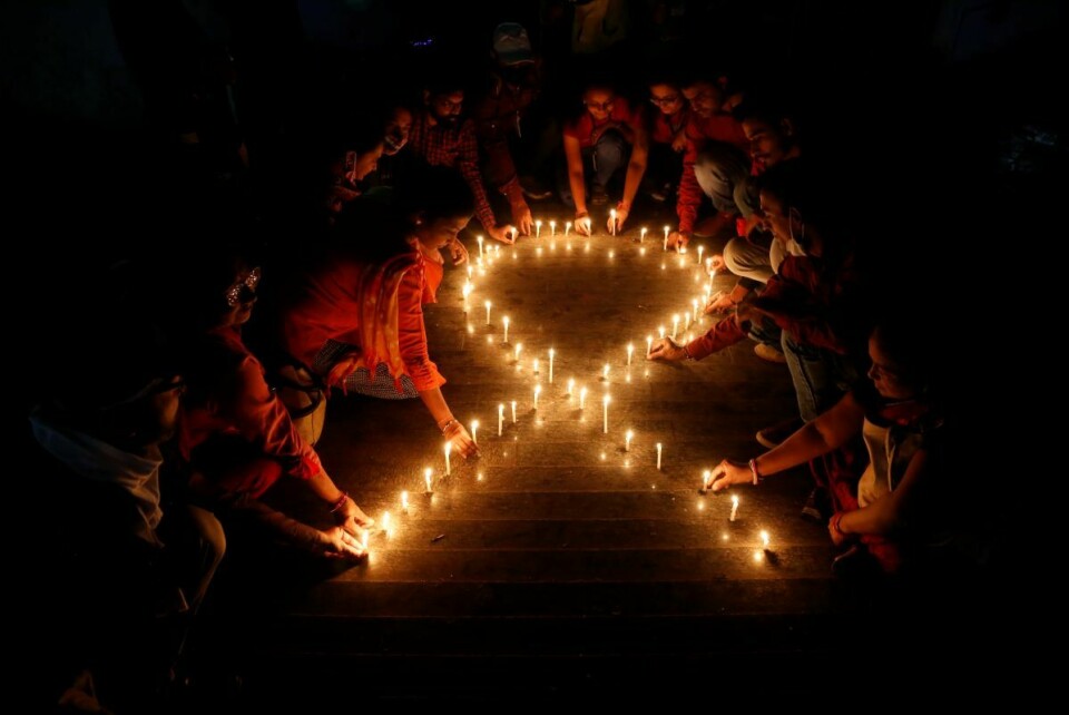 Medlemmer av en ikke-statlig, indisk organisasjon former en rød, lysende sløyfe. Røde sløyfe er en internasjonal solidaritetsaksjon for å vise støtte til kampen mot hiv og aids. Onsdag markeres verdens aidsdag. Foto: Ajit Solanki /AP /NTB