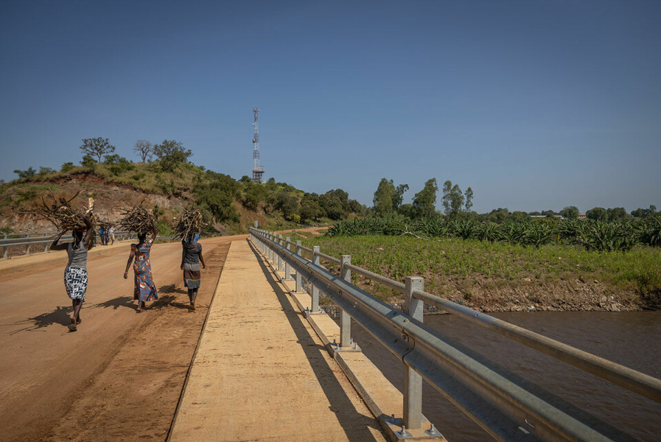 Kvinner bærer ved fra en side av elven i Pakwach til den andre. Elven, som renner fra DR Kongo går rett gjennom det omstridte området der Paten-klanen bor. Konfliktene, som blusset opp tidligere i år har gjort at innbyggerne er redde for å bevege seg fritt i området.