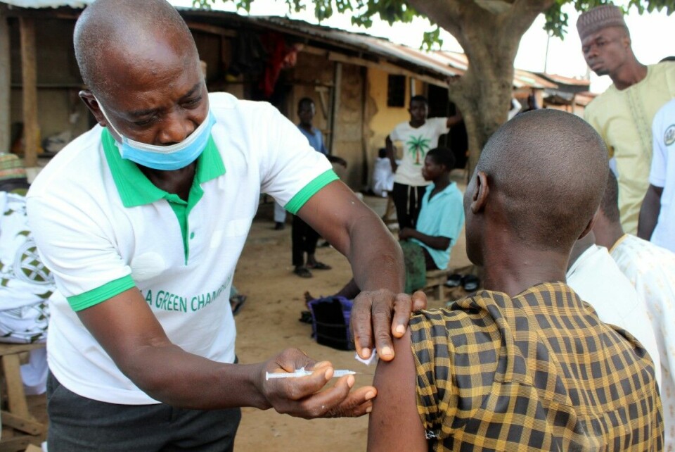En helsearbeider setter en dose av koronavkasinen Moderna utenfor en moske i Abudja i Nigeria. Mens Nigeria allerede er i gang med andre vaksinerunde, er mange andre land langt bak når det gjelder å vaksinere innbyggere. Foto: Gbemiga Olamikan/AP/NTB.