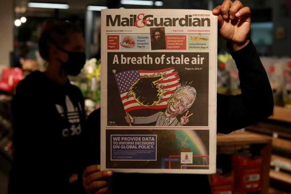 En karikatur av Joe Biden med Donald Trump som en svart flekk på det amerikanske flagget på forsiden av den sørafrikanske avisen Mail and Guardian fredag etter presidentvalget. Foto: Nardus Engelbrecht / AP / NTB