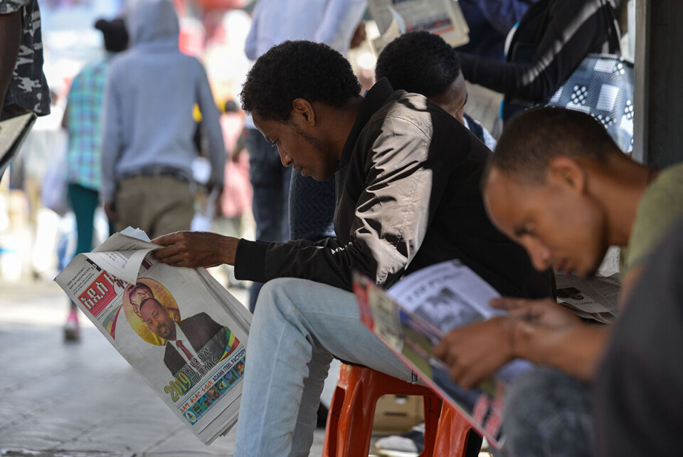 Folk på gata i hovedstaden Addis Abeba leser nyheten om at Nobelkomiteen i Oslo dagen i forveien hadde tildelt statsminister Abiy Ahmed fredsprisen. Hovedbegrunnelsen var tilnærmingen til nabolandet Eritrea. Foto: Michael Tewelde / AFP / NTB scanpix