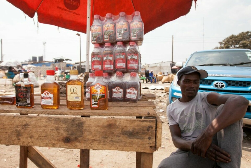 Forward Nyakuenda (26) har sin base i Mbare-distriktet, den eldste bydelen i hovedstaden Harare. Han heller den hjemmelagde spriten over på flasker med ulike merker. Salget gir gode inntekter. Foto: Wilfred Kajese/ Bistandsaktuelt.