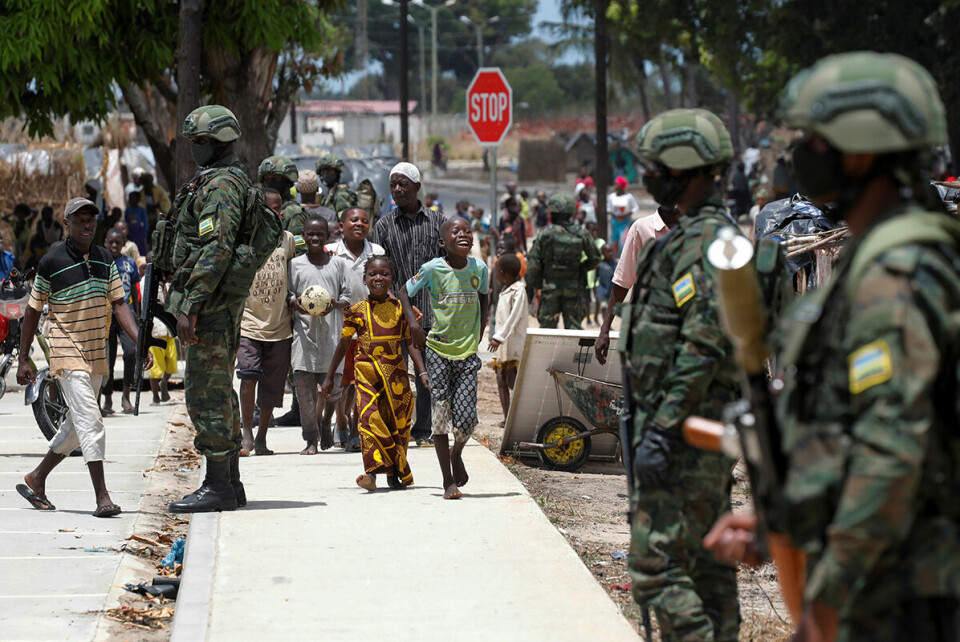 Rwandiske tropper utenfor en leir for internt fordrevne i byen Quitunda. Foto: Baz Ratner / Reuters / NTB