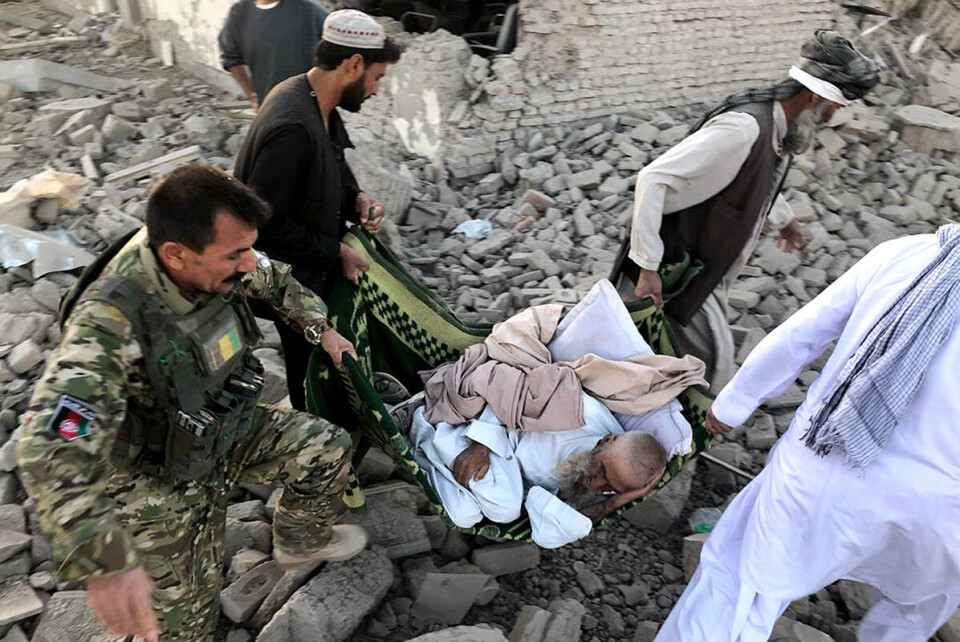 Afghanske sikkerhetsstyrker og frivillige bærer bort en såret mann etter bombeangrepet i provinshovedstaden i Zabul torsdag. Foto: Ahmad Wali Sarhadi / AP / NTB scanpix