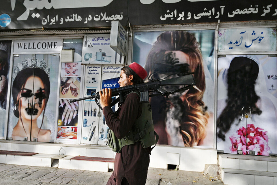 En taliban-kriger passerer forbi en nedstengt skjønnhetssalong i sentrum Kabul. Foto: Wakil Kohsar / AFP / NTB