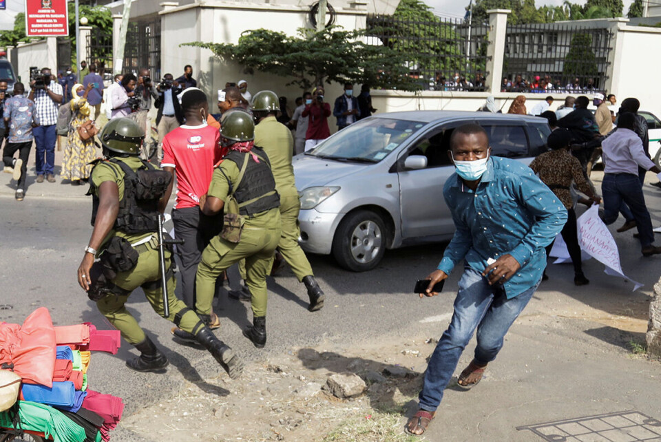 Støttespillere av opposisjonspartiet Chadema jages av politiet utenfor rettslokalet der partilederen i dag møter anklaget for terrorisme. Foto: Reuters /NTB