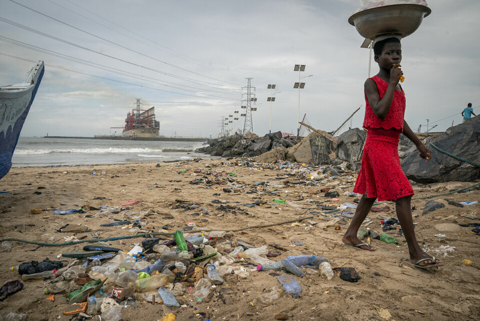 En jente går på en forsøplet strand i havnebyen Tema utenfor Accra i Ghana. Dårlig fiskeforvaltning og enorm forsøpling i havet og på land, hovedsakelig av plast, gjør at fiskerne tvinges til å ta lengre pauser fra fiskingen. Ventetiden blir brukt til å reparere båter og garn, men inntektene uteblir og fattigdomsproblemene øker. Foto: Heiko Junge / NTB scanpix