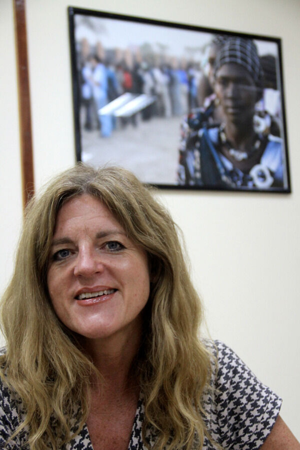- Det er bedre og mer troverdig når kritikk kommer innenfra, fra dem som selv har vært en del av historien, sier Hilde Frafjord Johnson. Bildet som pryder kontorveggen hennes i Juba er av den første kvinnen som stemte under landets første valg. Foto: Hege Opseth