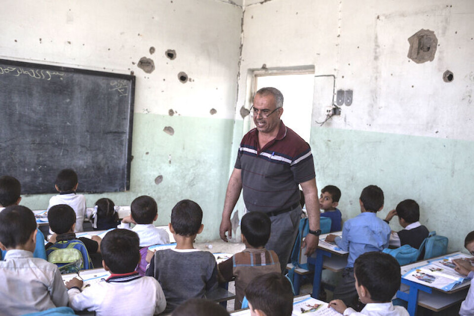 Den 47 år gamle læreren Awad er tilbake i klasserommet med sine elever. Kulehullene i veggene vitner om marerittet læreren og elevene opplevde da skolen deres i Mosul, nord i Irak, havnet i skuddlinjen mellom irakiske styrker og IS i 2017. Bildet er fra april 2018.