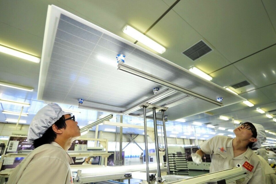 Kinas voldsomme økning i produksjon av solcellepaneler har ført til lavere priser for å installere solenergi. Bildet viser arbeidere hos solcellepanelprodusenten Yingli som inspiserer et panel.
