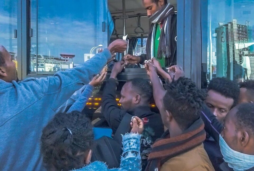 Folk strømmer til en lokal buss i Etiopias hovedstad Addis Abeba. Nå har også regionbussene gjenåpnet sine ruter. Myndighetene krever imidlertid nå av bussoperatørene at antallet passasjerer skal halveres og ombord i bussen skal det brukes munnbind. Foto: Ermyas Assefa