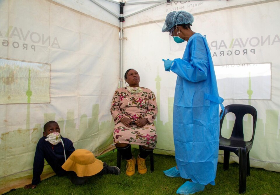 En kvinne og hennes sønn lytter mens en helsearbeider forklarer testprosedyren for korona-testing i en bydel av Johannesburg. Sør-Afrika er ett av få afrikanske land som har igangsatt omfattende testing av befolkningen i utsatte områder. Foto: Themba Hadebe / AP Photo / NTB scanpix
