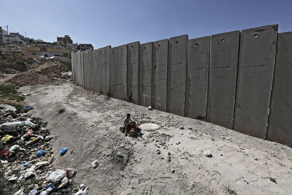 Human Rights Watch mener innskrenkinger av palestineres bevegelsesfrihet er blant tiltakene som gjør at organisasjonen nå betegner Israel som en apartheid-stat. Her leker en en liten gutt nær den israelske separasjonsmuren i flyktningleiren Shuafat på Vestbredden, rett utenfor Jerusalem. Foto: Ammar Awad / Reuters / NTB