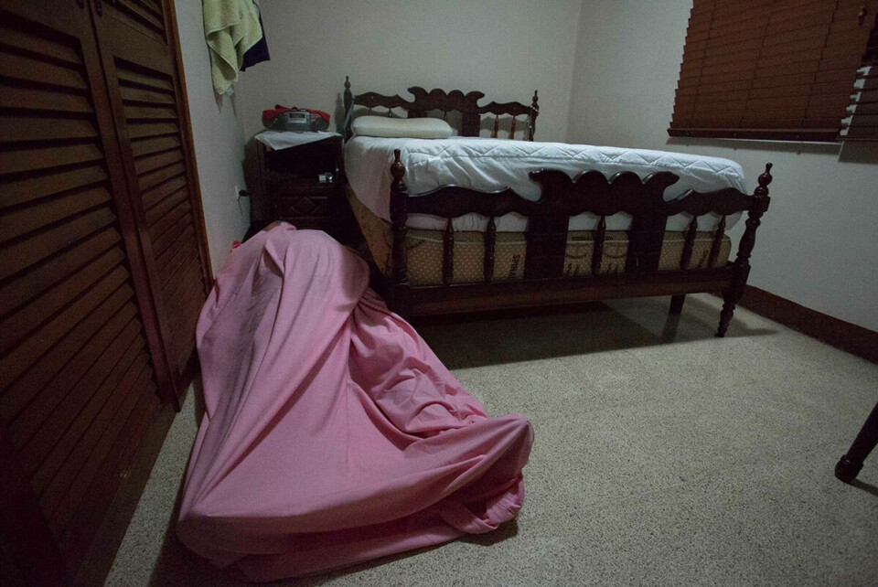 Patricias far ligger under et rosa laken på soverommet. Liket av den avdøde faren har ligget slik i to døgn, og familien har lagt avispapir i døråpningen for å redusere lukt.