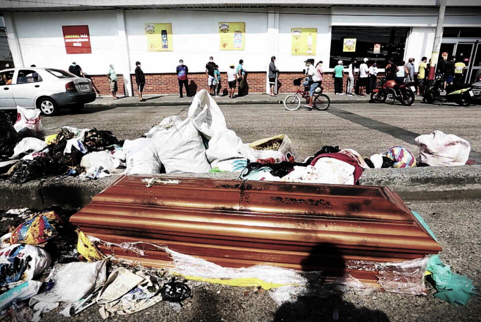 En lik-kiste er hensatt sammen med søppelet utenfor et supermarked. Koronapandemien har rammet Ecuadors største by hardt.