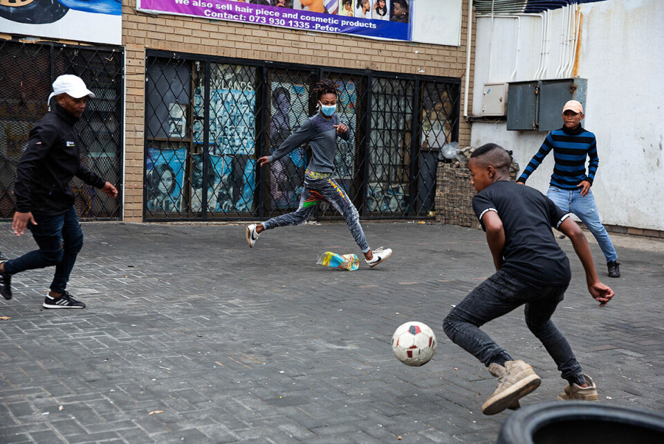 KORONA-DAGBOK FRA SØR-AFRIK 0304: Ungdommer spiller fotball i Newlands under portforbudet i Sør-Afrika. De bor i et tettbefolket område, med både uformelle boliger og falleferdige blokker. I motsetning til middelklasse-sørafrikanere som har hus med flere rom og haver, er det vanskelig for mange fra arbeiderklassen å følge de strenge portforbud-reglene. Tekst og foto: James Oatway for Bistandsaktuelt