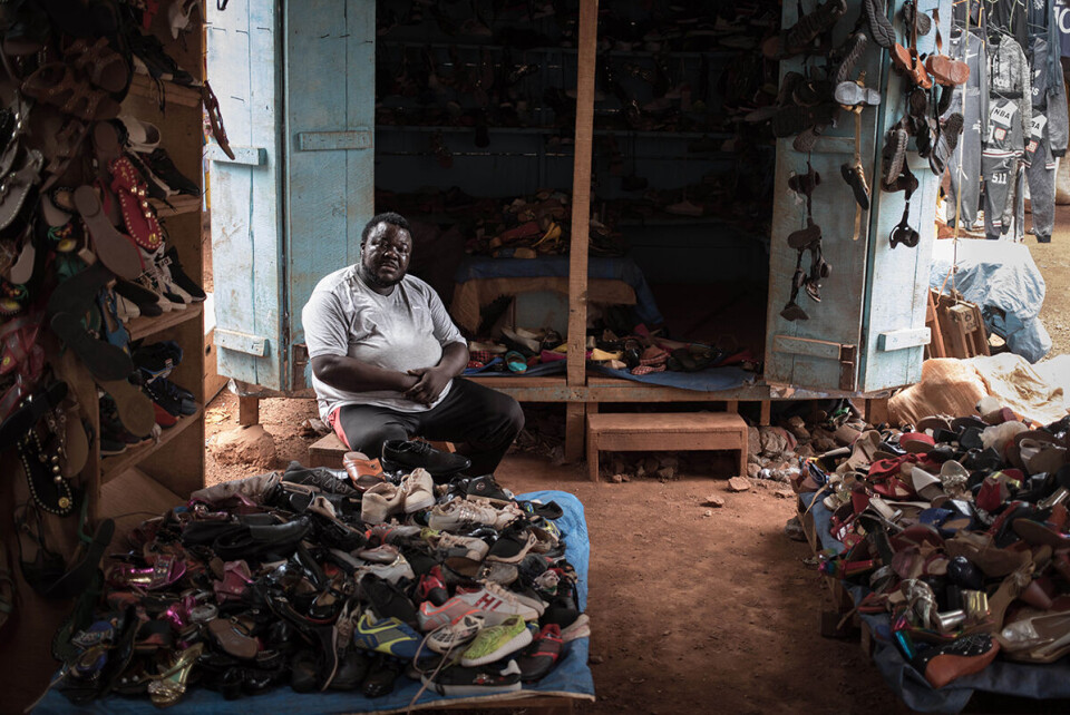 Skohandleren på markedet i Bangui sier han merker effekten restriksjonene. Få kunder har ført til et inntektstap på 80 prosent. Foto: Florent Vergnes / AFP / Bistandsaktuelt