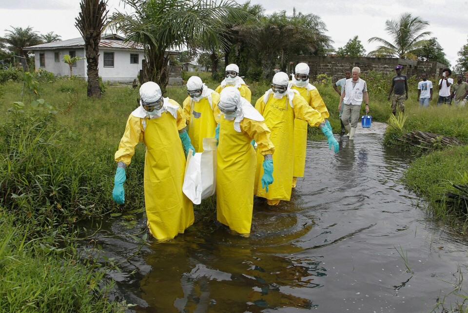 Helsearbeidere bærer enda et ebola-offer til graven under epidemien i 2014-16. Foto: Ahmed Jallanzo / NTB Scanpix