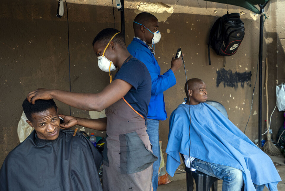 Frisører med beskyttelsesmasker på jobb i bydelen Soweto i Johannesburg i dag, onsdag 25. mars 2020. Sør-Afrikas president har varslet at landet skal iverksette strenge tiltak i et forsøk på å dempe koronaspredningen. Foto: Jerome Delay / AP / NTB scanpix