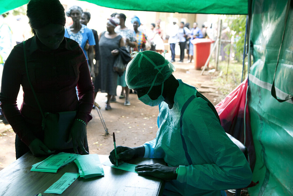 Folk i kø for å få målt kroppstemperaturen før de får komme inn på et offentlig sykehus i Zimbabwes hovedstad Harare. Foto: Tsvangirayi Mukwazhi / AP / NTB scanpix