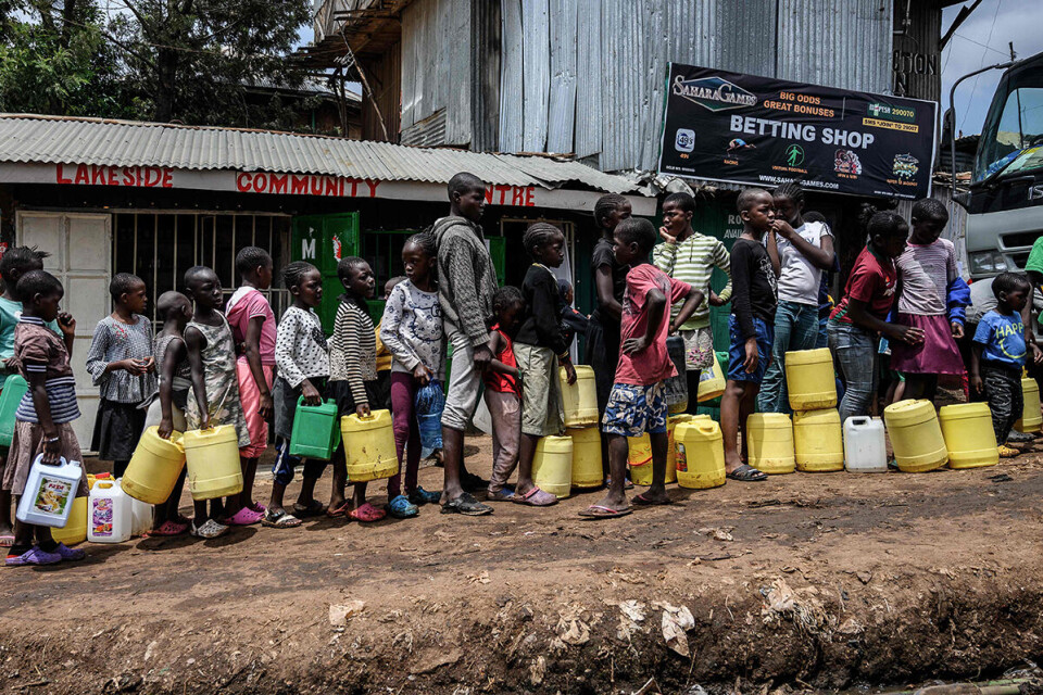 I vann-kø med jerry-kanner i Kibera-slummen: President Uhuru Kenyatta har kunngjort at folk med lav inntekt skal få utdelt vann som et tiltak for å hindre smitte av koronaviruset. Foto: Gordwin Odhiambo / AFP / NTB scanpix