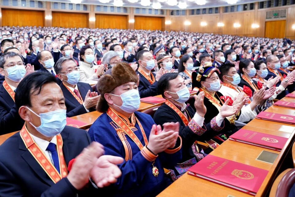 Tilhørere applauderer under seremonien for å markere slutten på ekstrem fattigdom i Kina torsdag. Seremonien ble avholdt i Folkets store hall i Beijing. Foto: Yan Yan, Xinhua via AP / NTB