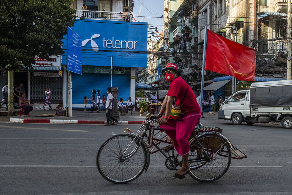 Yangon, 10 februar 2021: En demonstrant passerer et Telenor-utsalgssted i Myanmars største by, etter at enda en dag med protester endte uten vold i Yangon. Mange spør seg nå hvor lenge generalene vil tillate massedemonstrasjoner. Foto: Nyan Zay Htet