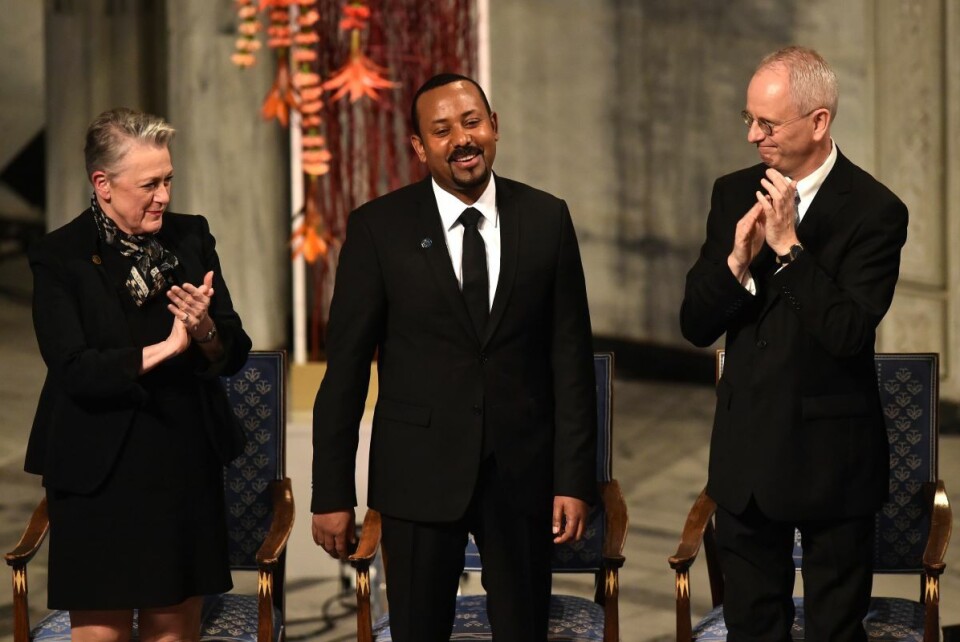 Nobelkomiteens leder Berit Reiss-Andersen (til v.) og nestleder Henrik Syse (til h.) applauderer Etiopias statsminister etter tildelingen av Nobels fredspris 10. desember 2019. Foto: Fredrik Varfjell / AFP / NTB