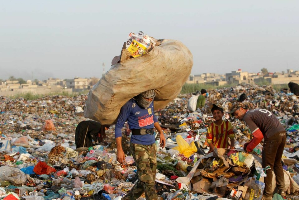 Uformell søppelplukker leter etter resirkulerbart avfall på en søppeldynge utenfor Bagdad i Irak. Foto: NTB