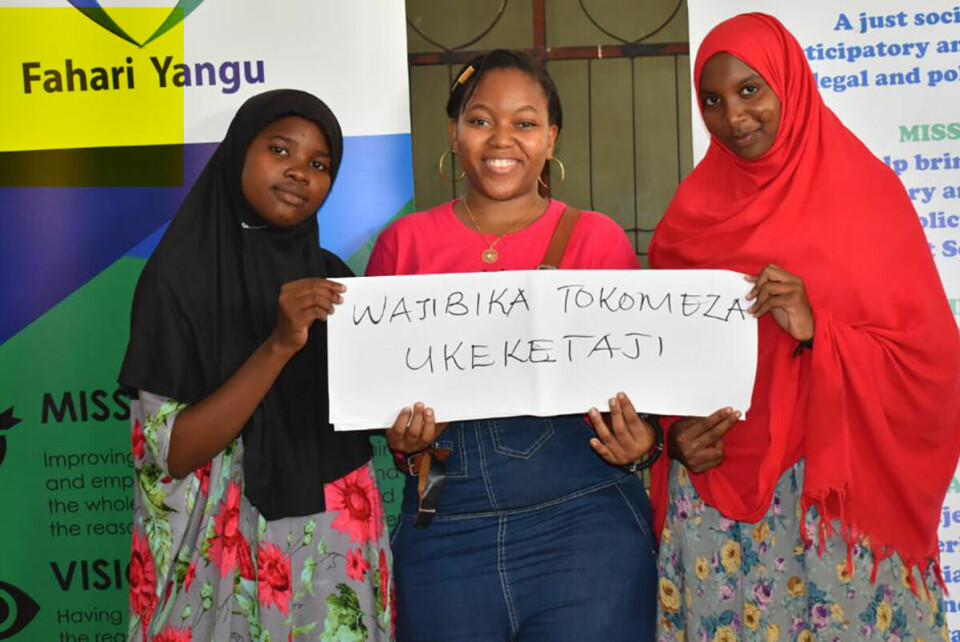 Ungdom i Youth for Change i Tanzania har gitt sine anbefalinger til hvordan den norske strategien mot skadelige skikker skal se ut. Jackline Octavian står i midten samme med Waida og Swaum (t.v). På plakaten står det: Ta ansvar, eliminer FGM (kjønnslemlestelse av kvinner).  Foto: Plan International