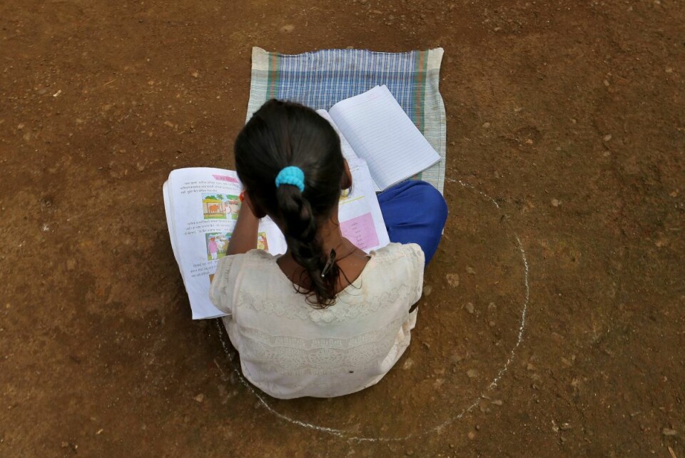 Selv med ulike nettløsninger og læringsapper står et flertall av indiske barn uten et reelt utdanningstilbud nå under korona-krisen. Denne skolejenta sitter i en sirkel som markerer avstanden hun må ha til sine medelever. Foto: NTB scanpix
