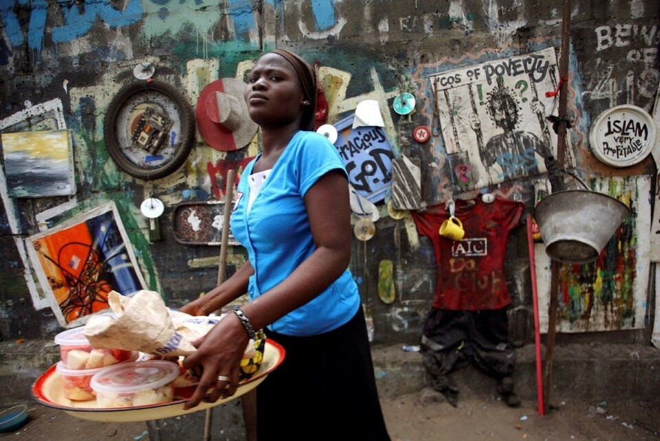 En kvinne selger mat på gata i Nigerias raskt voksende millionby Lagos. Framtidas afrikanske byer skapes nå, og de må utvikles ved å spørre de som bruker byrommet om råd, mener artikkelforfatteren. Foto: Akintunde Akinleye / Reuters / NTB scanpix