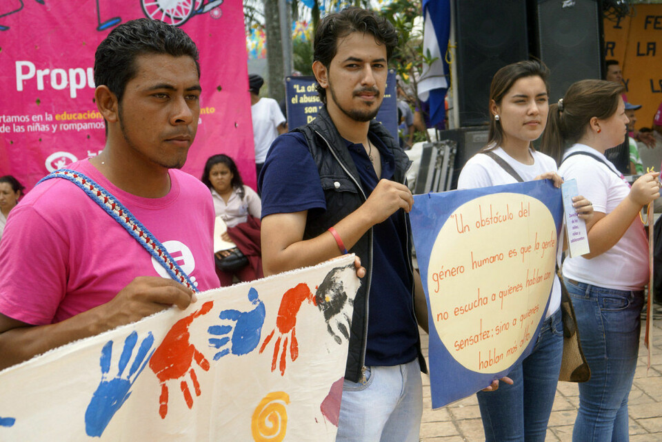 Kvinner og menn på gata i Honduras i en markering for barns rettigheter og for likestilling. Foto: Plan International