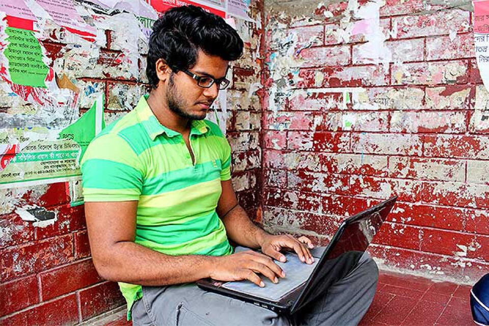 Mikrobiologistudenten Mehdi Hasan Imran (19) benytter en pause i studiene til å sjekke oppdateringene på Facebook. Foto: GMB Akash