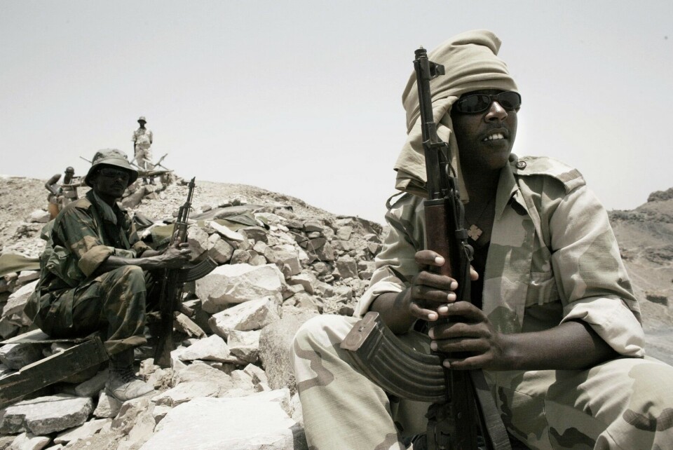 En grensedisputt om Ras Dumeira, en unnselig liten halvøy på grensa mellom Djibouti og Eritrea, har potensial til å utløse ny krig på Afrikas Horn. Bildet viser situasjonen i mai 2008. En djiboutisk soldat (i grønn uniform til venstre på bildet) sitter rett ovenfor eritreiske soldater (til høyre og i bakgrunnen), bare adskilt av en provisorisk steinmur som skilte partene.