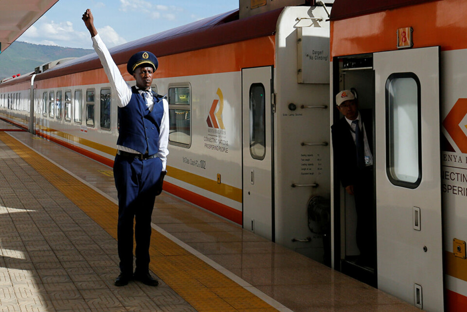 En konduktør fra Kenya Railways girsignal til lokføreren av et tog på Standard Gauge Railway (SGR)-linjen på Mai Mahiu-stasjonen. Toglinjen er konstruert av China Road and Bridge Corporation (CRBC) og finansiert av kinesiske myndigheter. Foto:Thomas Mukoya / Reuters / NTB