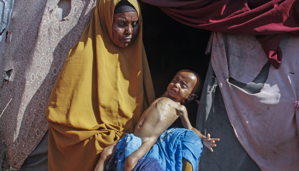 TØRKE: Boolo Aadan (63) holder sitt ni måneder gamle barnebarn på utsiden av Mogadishu, Somalia. Tørke har gjort at tusenvis av familier i regionen må flykte fra hjemmene sine og bo i teltleire.