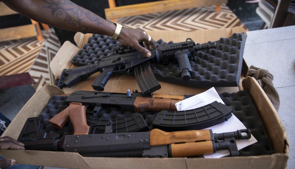 Gjengmedlemmer i koalisjonsgjengen G9 an fanmi pakker ut AK-rifler. Denne gjengen kontrollerer havneområdet i Port-Au-Prince.