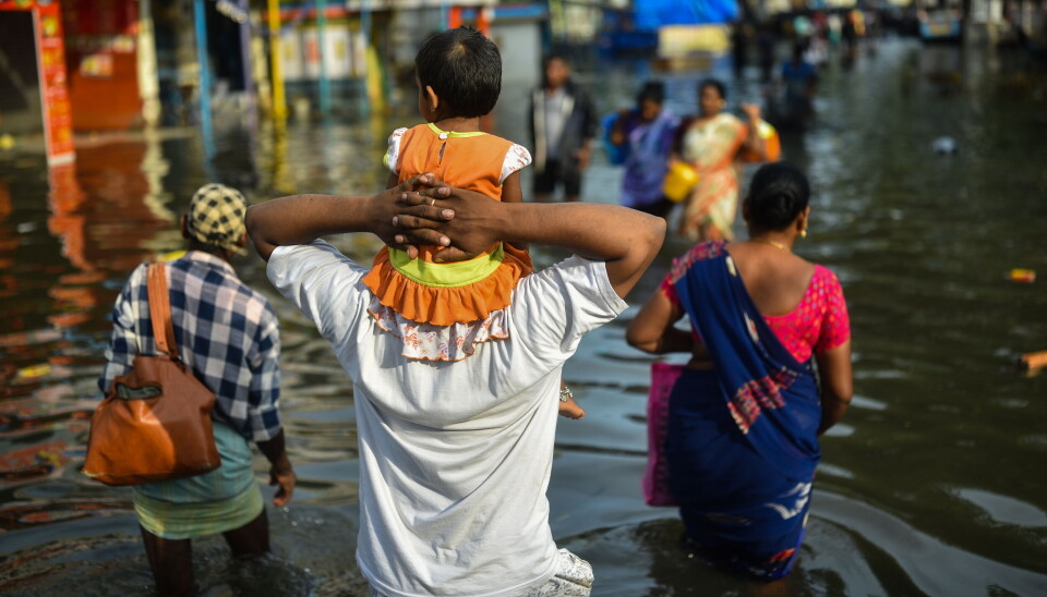 En far holder datteren sin på skuldrene etter ekstremvær i Chennai, India.