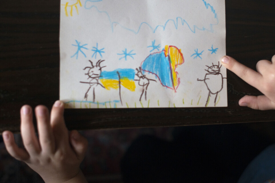 Seks år gamle Kyril måtte flykte fra hjembyen sammen med søsknene og moren. Her har han tegnet mamma, pappa og ham selv under ukrainske flagg.