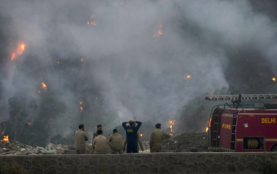 Brannfolk følger med på en stor søppelfylling som begynte å brenne under en ekstrem hetebølge i Indias hovedstad New Delhi i april. Hetebølgen er blitt satt i sammenheng med klimaendringene.