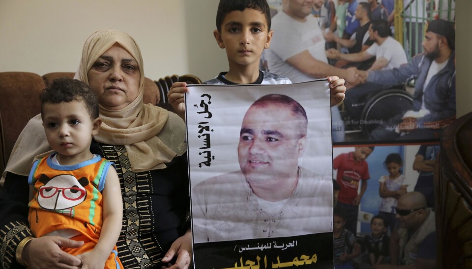 Amal el-Halabi med barnebarna Fares og Amro, som holder et bilde av faren Mohammed el-Halabi, leder av hjelpeorganisasjonen World Visions Gaza-kontor.