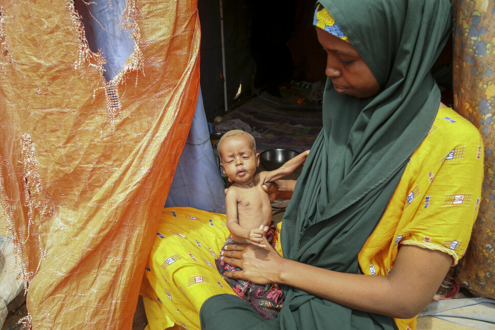 Amina Shuto (21) holder rundt sin to måneder gamle underernærte baby i en flyktningleir utenfor Mogadishu i Somalia. Shuto forteller at mange barn i området ikke får i seg nok næring.