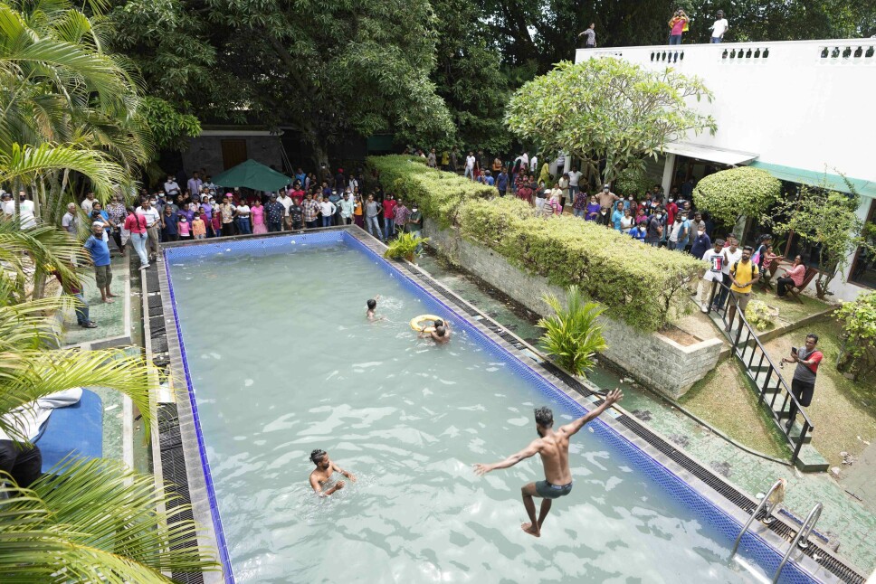 Demonstranter svømmer i Rajapaksas basseng etter at de stormet presidentpalasset søndag 10. juli.