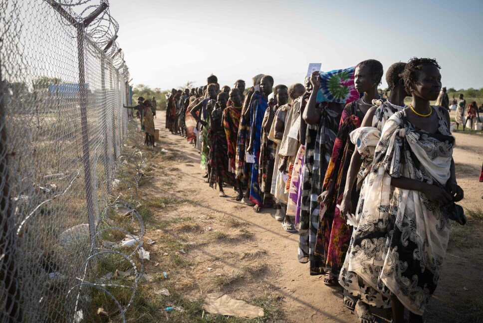 FNs matvareprogram deler ut mat til kvinner fra den etniske gruppen Murle, i Gumuruk, i Sør-Sudan, 10. juni 2021, etter at landsbyen deres ble angrepet av en væpnet milits. Etniske konflikter er del av et ekstremt komplekst årsaksbilde som gjør at brorparten av folket i Sør-Sudan lever under FNs fattigdomsgrense, på under 1,90 dollar dagen.