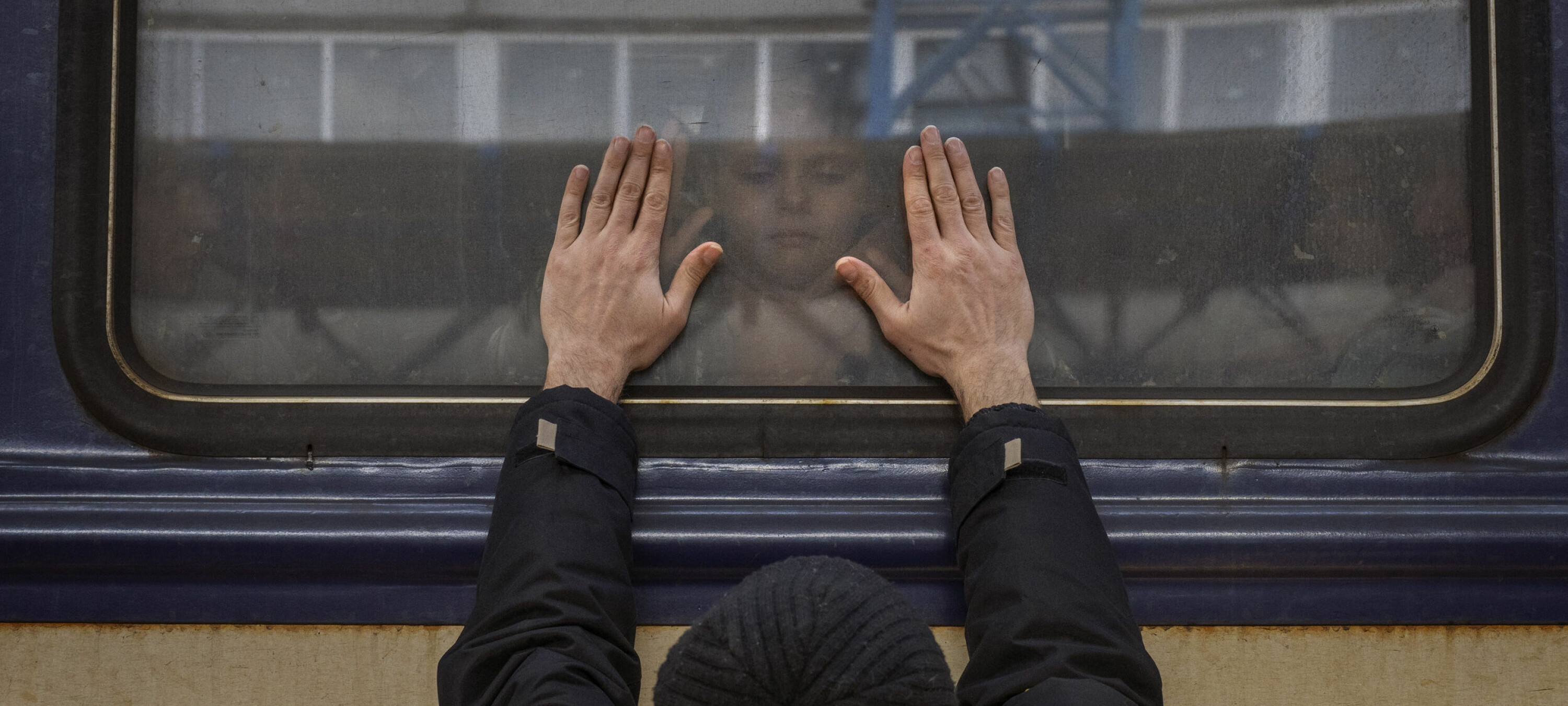 FILE - Aleksander, 41, presses his palms against the window as he says goodbye to his daughter Anna, 5, on a train to Lviv at the Kyiv station, Ukraine, Friday, March 4. 2022. Aleksander has to stay behind to fight in the war while his family leaves the country to seek refuge in a neighbouring country. (AP Photo/Emilio Morenatti, File)