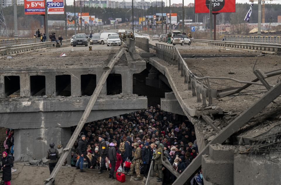 Ukrainere stimler sammen under ei ødelagt bru mens de forsøker å flykte ved å krysse Irpin-elva utenfor hovedstaden Kyiv 5. mars. Foto: Emilio Morenatti / AP / NTB