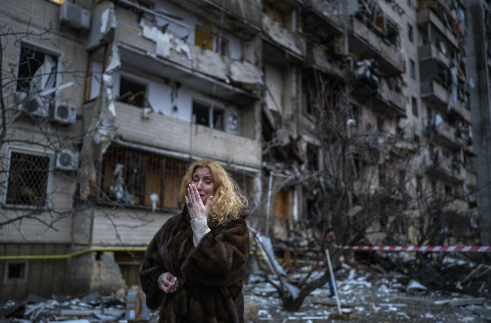 En kvinne utenfor huset sitt etter et rakettangrep i Kyiv 25. februar. Foto: Emilio Morenatti / AP / NTB