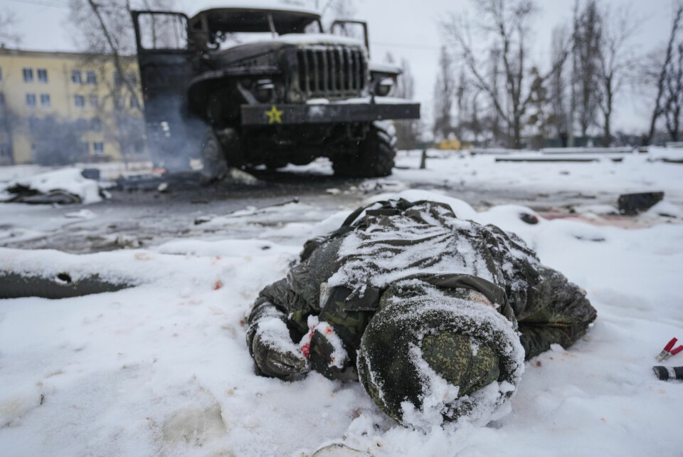 En drept soldat ligger ved et ødelagt russisk militærkjøretøy i utkanten av Kharkiv 25. februar. Foto: Vadim Ghirda / AP / NTB