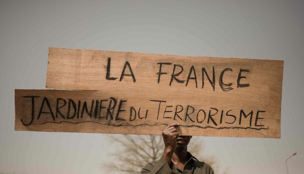 En demonstrant holder en plakat med påskriften 'Frankrike, en gartner for terrorisme' Bildet er tatt i forbindelse med en demonstrasjon i Bamako i februar 2022. I August 2022 trakk Frankrikes president Emmanuel Macron franske tropper ut av Mali. Foto: